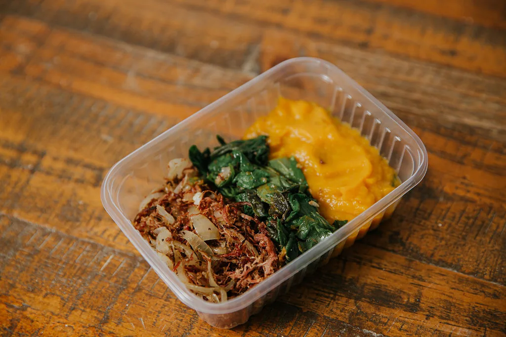 Marmita com carne desfiada, folhas refogadas e purê alaranjado
